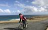 Skinny Tyres Ltd cyclist and road beside the sea