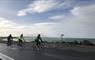 Skinny Tyres Ltd 3 cyclists on road beside the sea