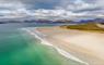 Aerial view of Luskentyre beach with stunning mountains in the background, showcasing natural beauty and serene landscapes.