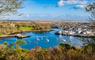 A picturesque harbour scene in Stornoway, with fishing boats and woodland area adjacent to Lews Castle grounds.